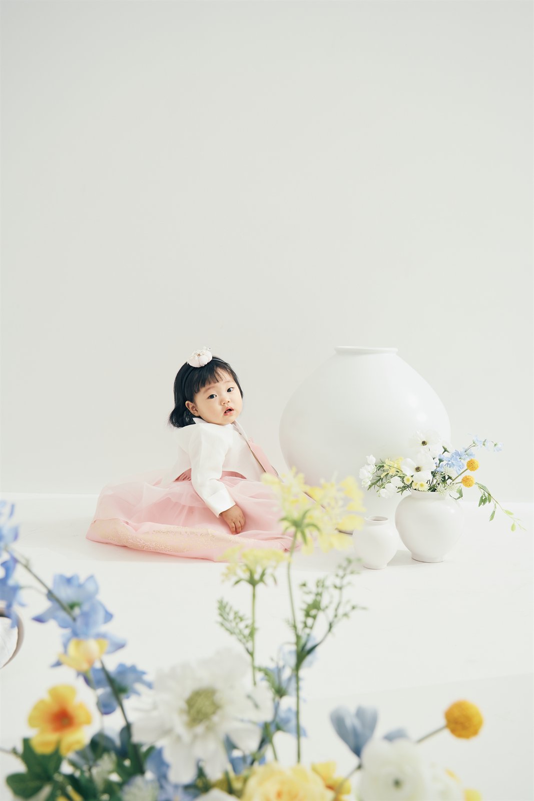 꽃과 달항아리 사이에 앉아 있는 박주이
