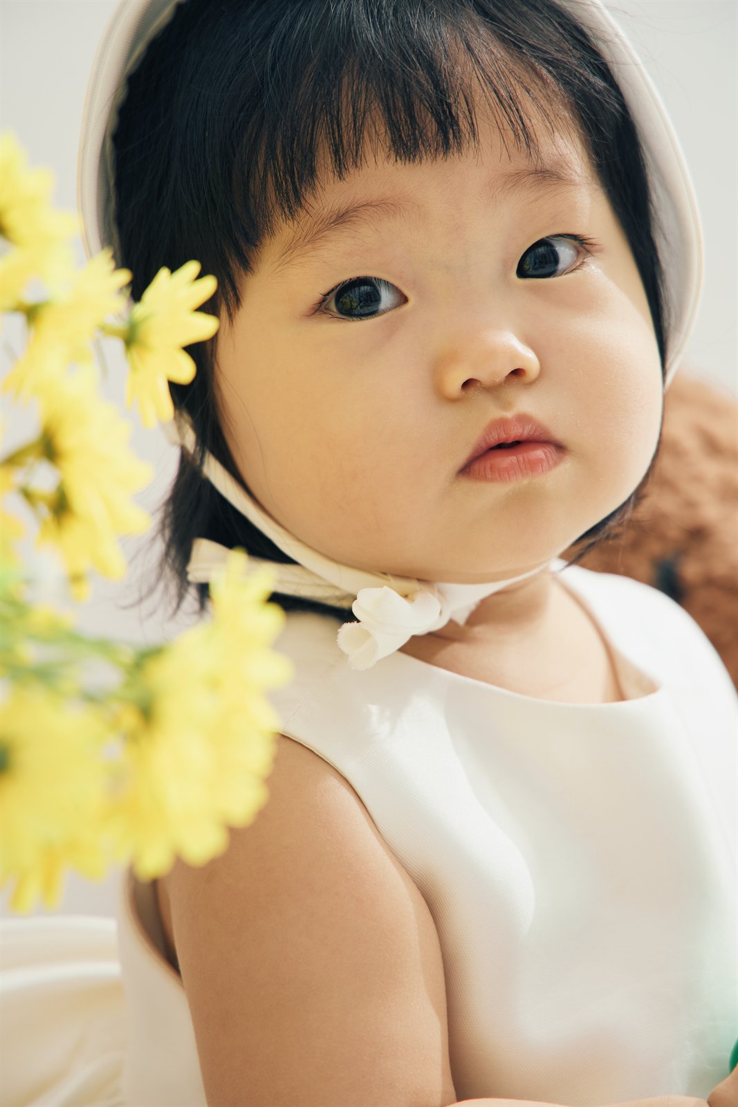 노란 꽃 옆에서 카메라를 바라보는 박주이